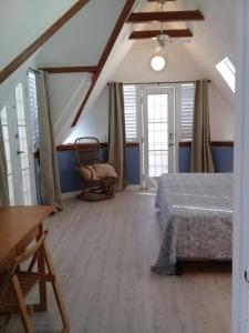 a bedroom with a bed and a chair in a room at Trinidad Gingerbread House in Port-of-Spain