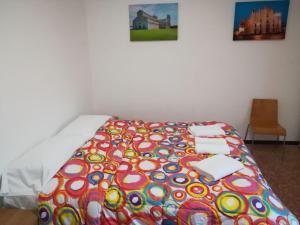a bed with a colorful blanket on top of it at Venice Park House in Marghera