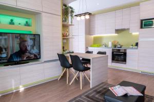 a kitchen with a table and chairs and a tv at Defne Apartman in Debrecen