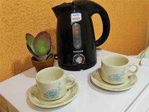 a coffee maker and two cups on a counter at Giova Apart Salta in Salta