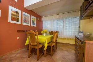 a dining room with a yellow table and chairs at Holiday Home Nives in Tivat