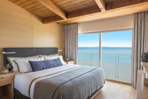 um quarto com uma cama grande e uma janela grande em Malibu Beach Inn em Malibu