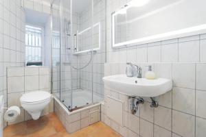 La salle de bains est pourvue d'un lavabo, de toilettes et d'une douche. dans l'établissement BIG CENTRAL CITY APARTMENT, à Berlin