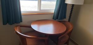 einen Holztisch und zwei Stühle vor einem Fenster in der Unterkunft Pacific Inn in Crescent City