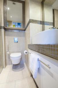 a bathroom with a toilet and a tub and a sink at Old Town Kalēju Street in Rīga +24 photos