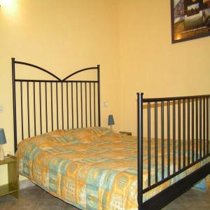 カステルヌオーヴォ・ディ・ガルファニャーナにあるAgriturismo La Palazzinaのベッドルーム1室(錬鉄製のヘッドボード付きのベッド1台付)