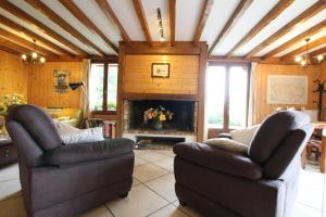 a living room with two chairs and a fireplace at L'espiatet in Borce