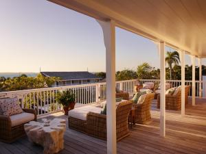 a porch with couches and a table on a deck at Eleven Bahama House in Harbour Island