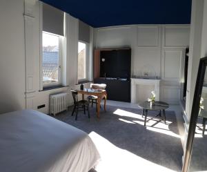 a bedroom with a bed and a table and a kitchen at LA VILLA DES CHAMPS in Lille
