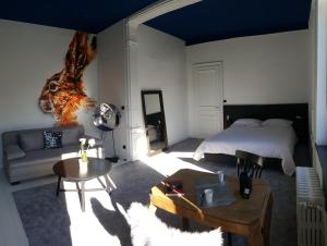 ein Schlafzimmer mit einem Bett, einem Sofa und einem Tisch in der Unterkunft LA VILLA DES CHAMPS in Lille