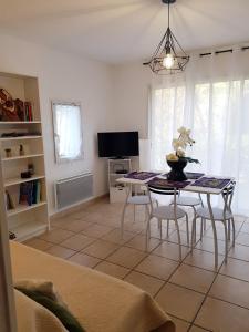- un salon avec une table, des chaises et une télévision dans l'établissement Appartement 60m2 tout confort, à Fréjus