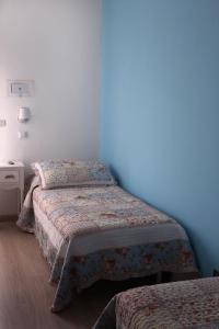 1 dormitorio con 2 camas y pared azul en Hotel Santiago, en Milano Marittima