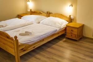 sypialnia z 2 łóżkami z białą pościelą i stolikiem nocnym w obiekcie Pizzerie Jasany w mieście Nový Šaldorf