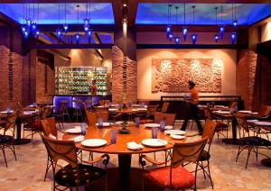 a restaurant with tables and chairs and a person in the background at Radisson Blu Plaza Delhi Airport in New Delhi