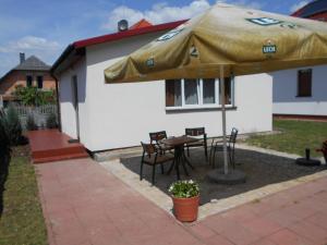 een patio met een tafel en stoelen en een parasol bij domek Boszkowianka Mini in Boszkowo