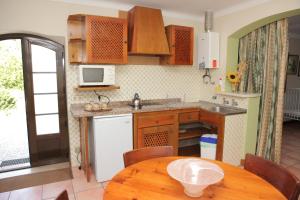 uma cozinha com armários de madeira e uma mesa de madeira em Quinta de Rio Alcaide em Porto de Mós