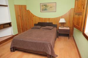 a bedroom with a bed and a lamp on a wooden floor at Quinta de Rio Alcaide in Porto de Mós