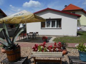 een huis met een paraplu en een tafel met bloemen bij domek Boszkowianka Mini in Boszkowo