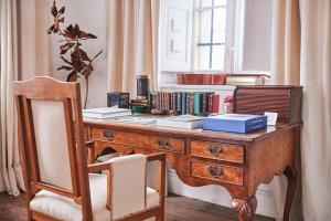 un escritorio de madera con una silla y libros. en La Tudanca, en Sobremazas