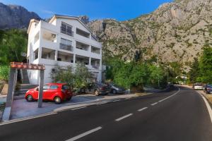 a red car parked in front of a white building at Sea Star Luxury Apartment in Kotor