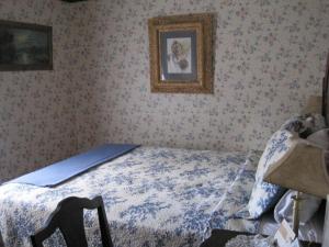 1 dormitorio con 1 cama y una foto en la pared en Colonial Charm Inn Bed & Breakfast, en Charlottetown