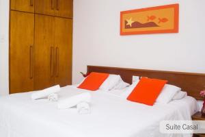 2 camas con almohadas de color naranja y blanco en una habitación en Porto seguro Residencial Jerusalem 1, en Porto Seguro