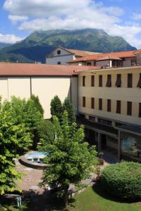 a view of the courtyard of a hotel with mountains in the background at Casa per ferie Al Centro in Belluno