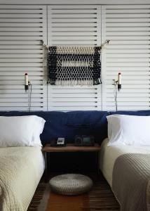 
a bed sitting next to a wall next to a lamp at Ace Hotel and Swim Club Palm Springs in Palm Springs
