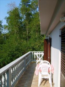 a porch with a white chair and a table at Apartment in Lopar/Insel Rab 17747 in Lopar