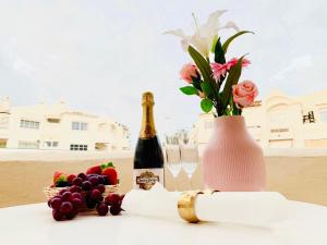 butelkę szampana i wazę z kwiatami i owocami w obiekcie Apartamento Marina Loft w mieście Benalmádena +37 zdjęć
