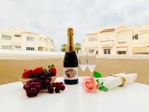 butelkę szampana i winogrona oraz kosz kwiatów w obiekcie Apartamento Marina Loft w mieście Benalmádena