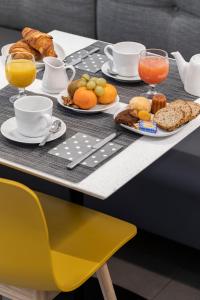 - une table avec des aliments et des boissons pour le petit-déjeuner dans l'établissement Hôtel La Cour Carrée Bordeaux Centre, à Bordeaux