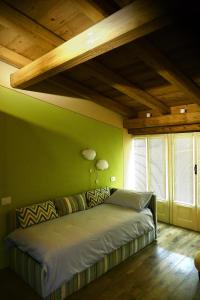 a green bedroom with a bed and wooden ceilings at Villa Rostagno in Entracque