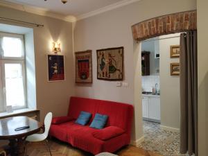 czerwona kanapa z dwoma niebieskimi poduszkami w salonie w obiekcie Krakowsky Apartment w Krakowie