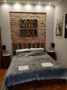 ein Schlafzimmer mit einem Bett und einer Ziegelwand in der Unterkunft Krakowsky Apartment in Krakau