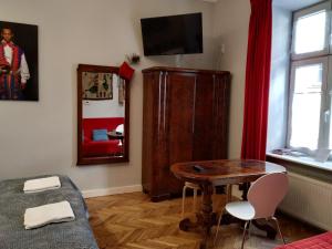 ein Wohnzimmer mit einem Tisch, einem Stuhl und einem Spiegel in der Unterkunft Krakowsky Apartment in Krakau