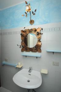a bathroom with a sink and a mirror on the wall at ISS Travel, Villa Fiorita - 800 m from La Cinta beach in San Teodoro