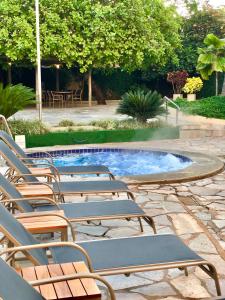 卡爾達斯諾瓦斯的住宿－Pousada das Aguas，一组椅子坐在游泳池旁
