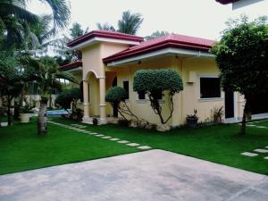 a house with a green lawn in front of it at Kim Beatriz Compound in Mactan