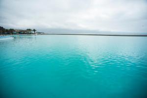 un gran cuerpo de agua azul con el océano en el fondo en San Alfonso Del Mar Apartment, en Algarrobo