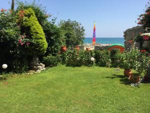 a garden with flowers and a view of the ocean at Asterias Studios & Apartments in Kalyves