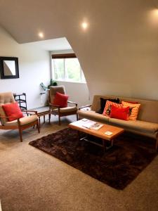 a living room with a couch and two chairs at Lavender Hill in Riverhead