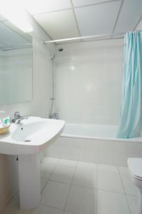 a white bathroom with a sink and a shower at Apart-Hotel Golf Beach 35201 in Begur