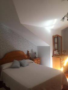 Schlafzimmer mit einem weißen Bett und einem Spiegel in der Unterkunft Casa Roque in Gondomar