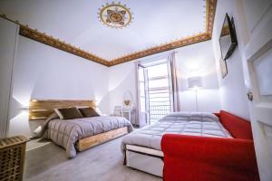 a bedroom with two beds and a red couch at B&B Opera dei Pupi in Palermo