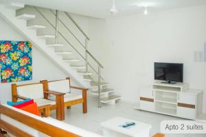 sala de estar con escalera y TV en Porto Seguro. Residencial Monte Hebron ., en Porto Seguro