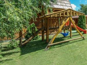 un parque infantil con un tobogán en un patio en Csatári Pensiune Praid, en Praid