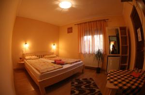 1 dormitorio con 2 camas y ventana en Csatári Pensiune Praid en Praid