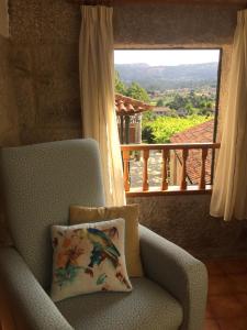 une chaise avec un oreiller en face d'une fenêtre dans l'établissement Casa Roque, à Gondomar