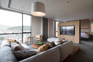 a living room with a couch and a large window at Cross Hotel Kyoto in Kyoto